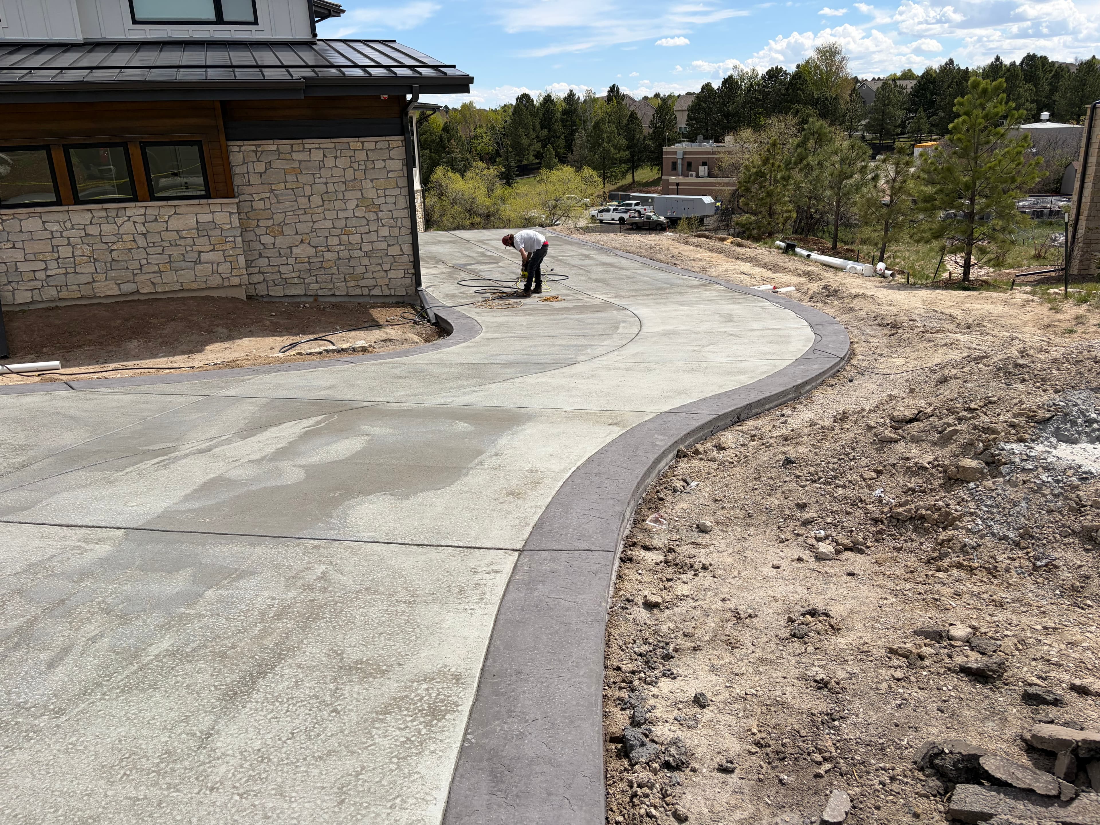 Curving concrete driveway at a stone-faced foothills home