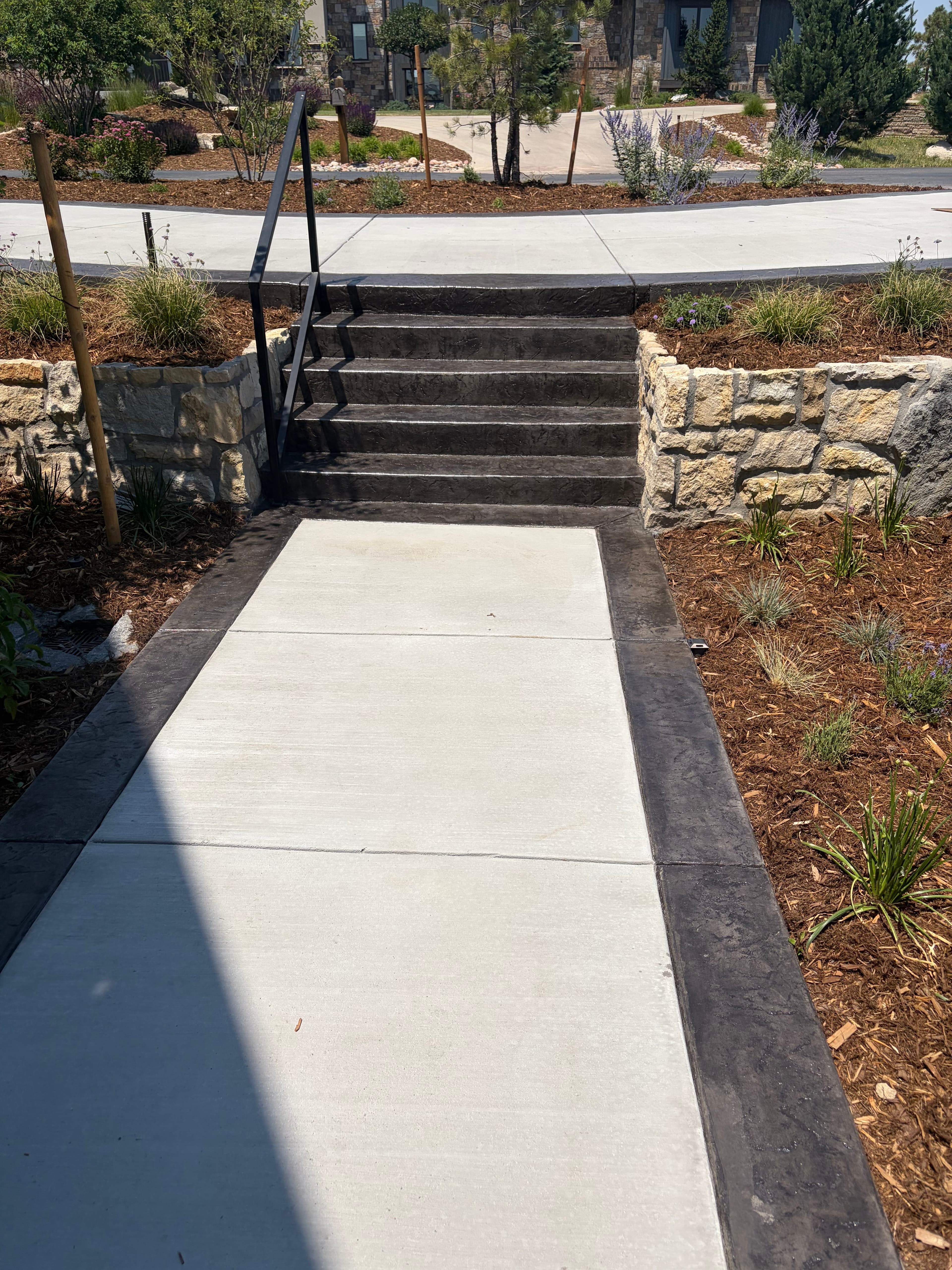 Concrete steps with a stamped border built into a stone retaining wall