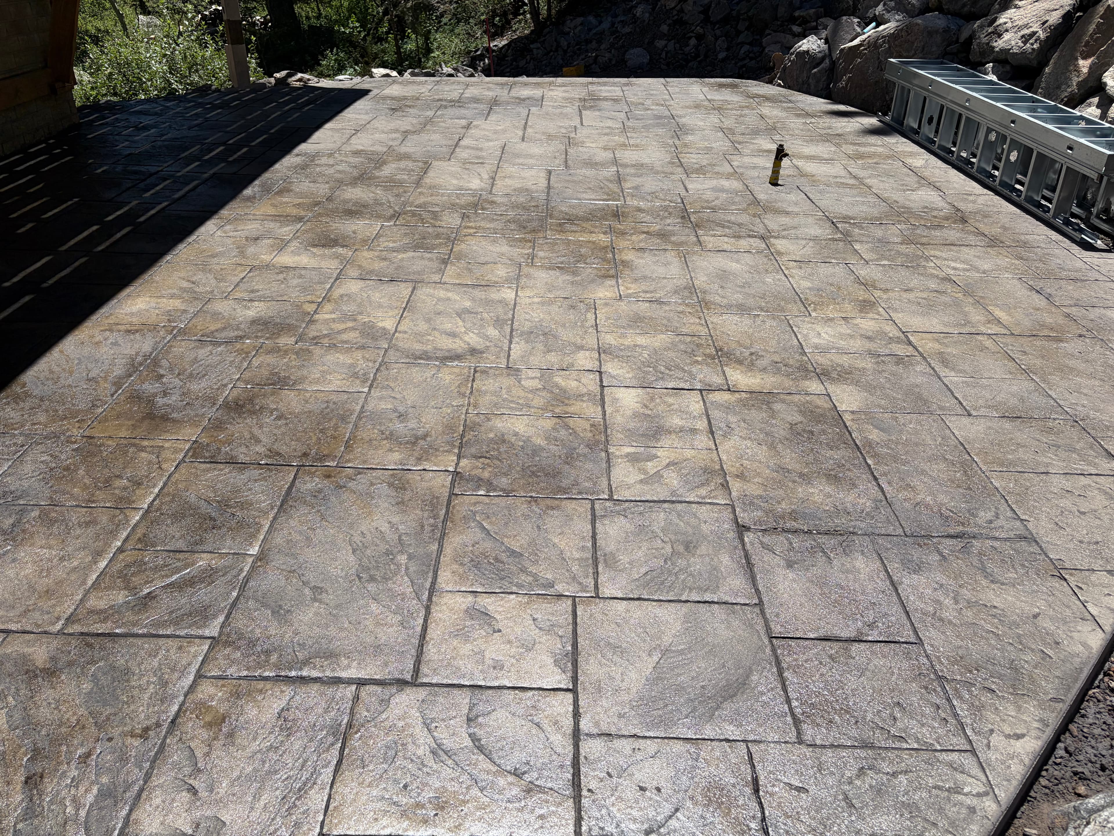 Large stamped concrete patio with a stone-tile pattern finish